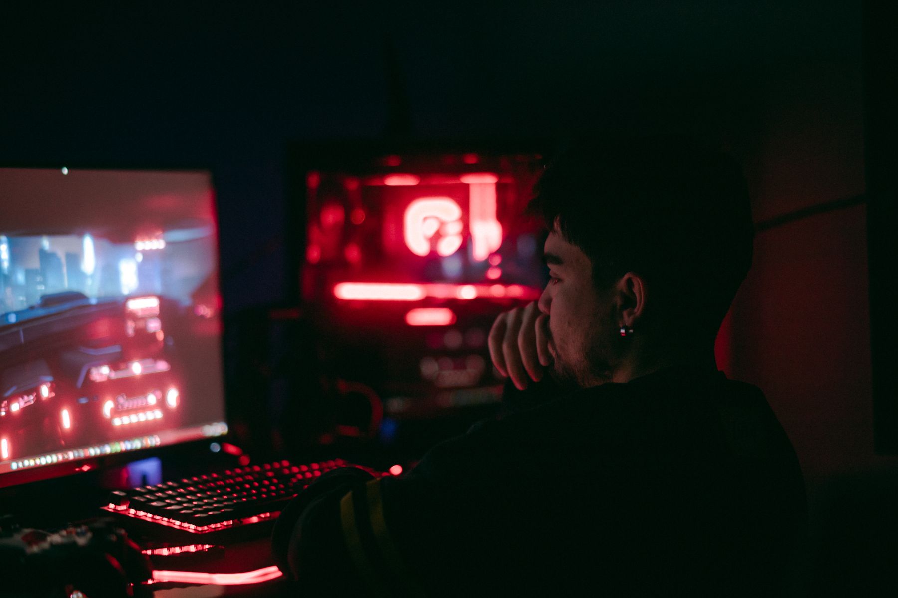 Player immersed in a dark gaming setup