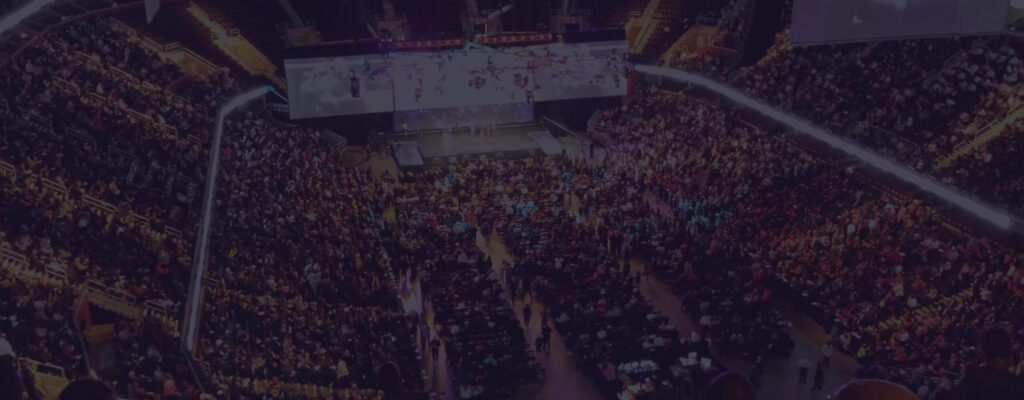 Esports stadium filled with fans watching a competitive video game tournament, representing video game marketing, player growth, and online visibility.
